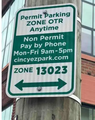 a sign on a wooden pole with a parking sign at OTR by TQL+King Bed+Light Rail+Dedicated Parking in Cincinnati
