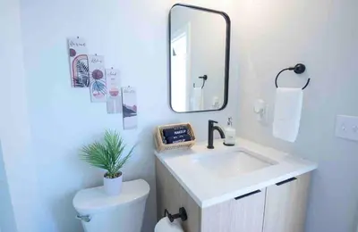 a bathroom with a sink and a mirror and a toilet at OTR by TQL+King Bed+Light Rail+Dedicated Parking in Cincinnati