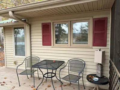 a patio with two chairs and a table on a porch at House Upon a Hill in Newton Falls