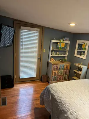 a bedroom with a bed and a window and a wooden floor at House Upon a Hill in Newton Falls