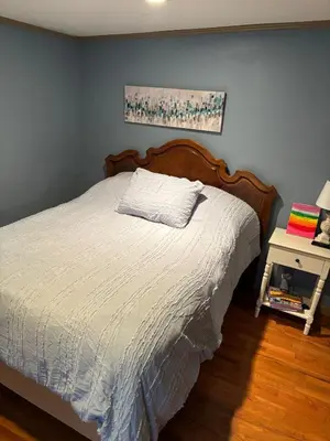 a bedroom with a bed with a white comforter at House Upon a Hill in Newton Falls