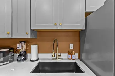 a kitchen with a sink and white cabinets at Sleeps 24/ 4 Kitchens / 4 Hot Tubs / 4 Firepits in Stanton