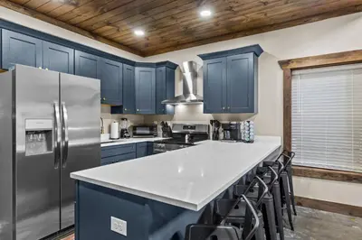 a kitchen with blue cabinets and a white counter top at Sleeps 24/ 4 Kitchens / 4 Hot Tubs / 4 Firepits in Stanton