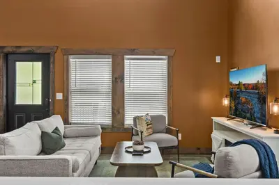 a living room with a couch and a tv at Sleeps 24/ 4 Kitchens / 4 Hot Tubs / 4 Firepits in Stanton