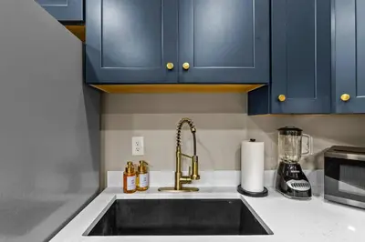 a kitchen counter with a sink and blue cabinets at Sleeps 24/ 4 Kitchens / 4 Hot Tubs / 4 Firepits in Stanton