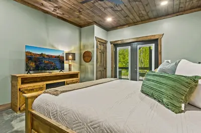 a bedroom with a large bed and a desk at New/12 Guest /2 Hot Tubs/ 2 Kitchens/ 2 Firepits in Stanton
