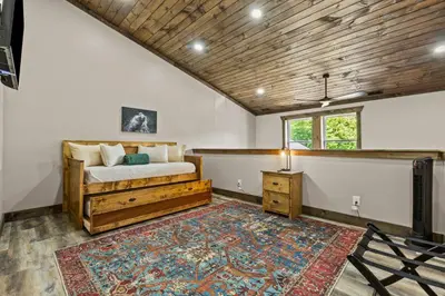 a bedroom with a bed and a rug at New/12 Guest /2 Hot Tubs/ 2 Kitchens/ 2 Firepits in Stanton