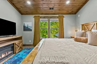 a large bedroom with a large bed and a fireplace at New/12 Guest /2 Hot Tubs/ 2 Kitchens/ 2 Firepits in Stanton