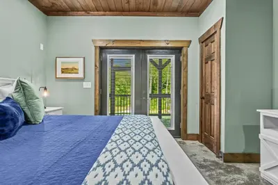 a bedroom with a blue bed and a window at New/12 Guest /2 Hot Tubs/ 2 Kitchens/ 2 Firepits in Stanton