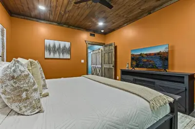a bedroom with a bed and a fireplace at New Barn/ Sleeps 12/ 2 Hot Tubs/ EV Charger in Stanton