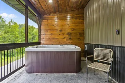 a tub in a room with a chair and a window at New Barn/ Sleeps 12/ 2 Hot Tubs/ EV Charger in Stanton