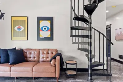 a living room with a couch and a spiral staircase at New Barn/King Beds/Hot Tub/Spacious Level Parking in Stanton