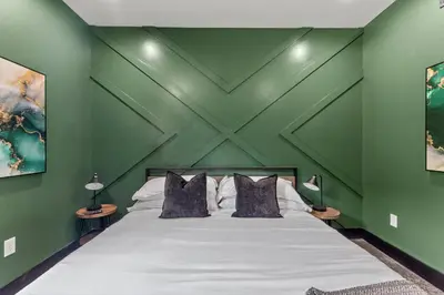 a bedroom with a green wall with a bed at New Barn/King Beds/Hot Tub/Spacious Level Parking in Stanton