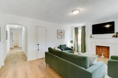 a living room with a green couch and a fireplace at Walk to Ritter Park Renovated Home Near Marshall! in Huntington