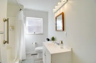 a white bathroom with a sink and a toilet at Walk to Ritter Park Renovated Home Near Marshall! in Huntington