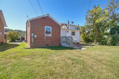 a brick house with a garage on a yard at Walk to Ritter Park Renovated Home Near Marshall! in Huntington