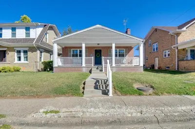 a house with a front porch with a blue door at Walk to Ritter Park Renovated Home Near Marshall! in Huntington