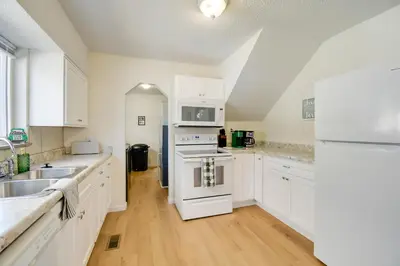 a kitchen with white cabinets and a sink and a stove at Walk to Ritter Park Renovated Home Near Marshall! in Huntington