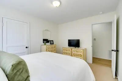 a bedroom with a white bed and a television at Walk to Ritter Park Renovated Home Near Marshall! in Huntington