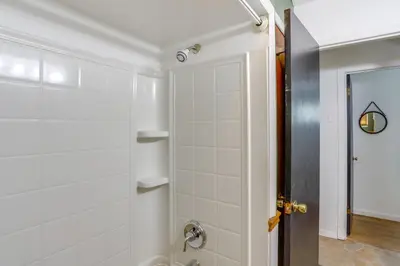 a bathroom with a shower with white tile at Steps to Lake Erie! Cedar Point Home Base with Deck in Sandusky