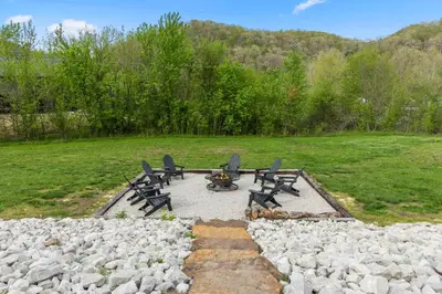 a fire pit with chairs and a table and rocks at Barndo/Ample Parking/Access to Red River/Hot Tub in Stanton