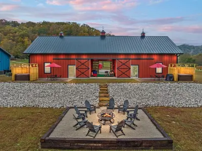 a red barn with chairs in front of it at Barndo/Ample Parking/Access to Red River/Hot Tub in Stanton