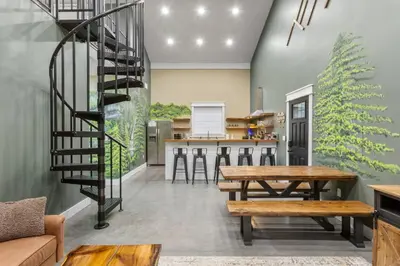 a kitchen with wooden tables and a spiral staircase at New Barndo/Red River Access/King Beds/Hot Tub in Stanton