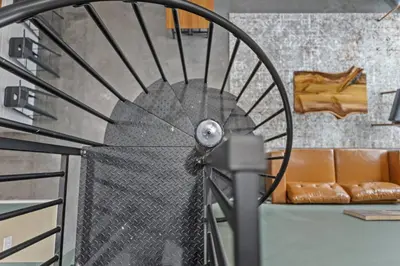 a large metal wheel in a room with a couch at New Barndo/Red River Access/King Beds/Hot Tub in Stanton