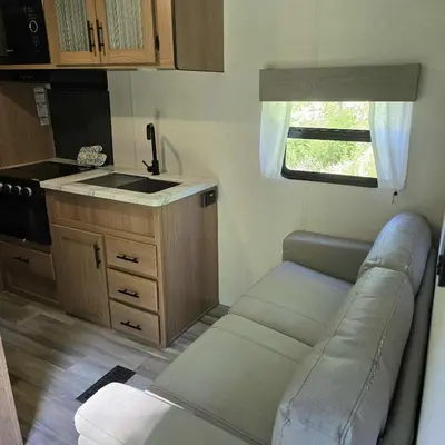 a living room with a couch and a kitchen at Monday creek camper in New Straitsville