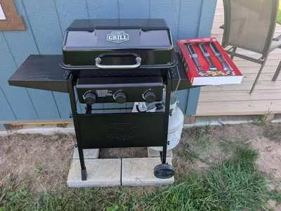 a grill sitting on a table next to a table at Little house on the prairie