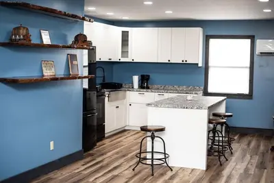 a kitchen with blue walls and a counter with stools at Little house on the prairie