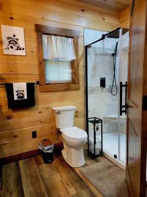 a bathroom with a toilet and a shower at WildWood Cabin in Gambier