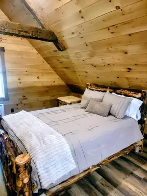 a bedroom with a bed in a log cabin at WildWood Cabin in Gambier