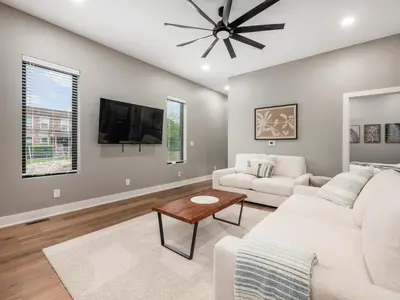 a living room with a white couch and a tv at New Build OSU Short North Dtown in Columbus