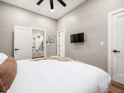 a bedroom with a white bed and a flat screen tv at New Build OSU Short North Dtown in Columbus