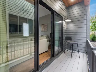 a screened porch with sliding glass doors and a stool at New Build OSU Short North Dtown in Columbus