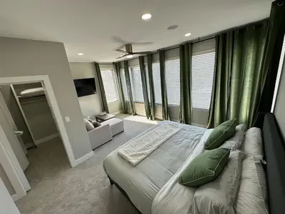 a bedroom with a bed and a couch and windows at New Build, Downtown Views, next to NCH in Columbus