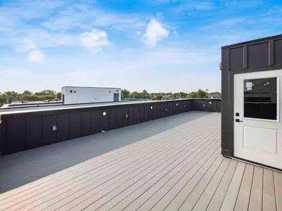 a wooden deck with a white door on a roof at New Build, Downtown Views, next to NCH in Columbus