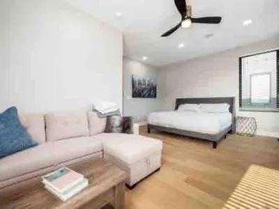 a living room with a couch and a bed at Brand NEW Build, D-Town Views, must See in Columbus