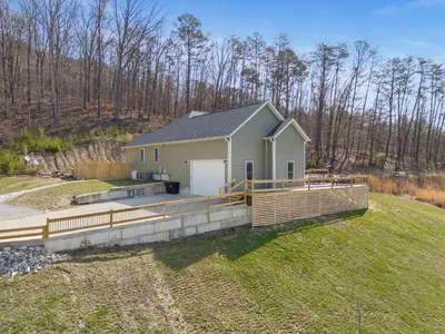 a home with a large deck in a field at Arch Fun Lodge - Game Room, Theater, HotTub & View in Stanton