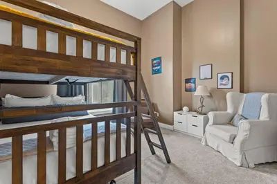 a bedroom with a bunk bed and a chair at Arch Fun Lodge - Game Room, Theater, HotTub & View in Stanton