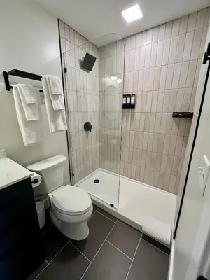 a bathroom with a white toilet and a shower at The Produce Suites in Toledo