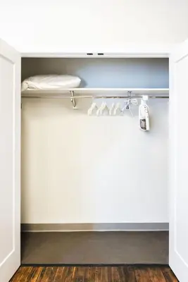 a room with a closet with white walls and wood floors at The Produce Suites in Toledo