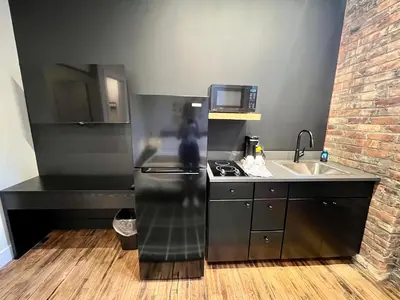 a kitchen with a black refrigerator and a sink at The Produce Suites in Toledo