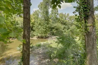 a river through a forest with trees at 1 Block to Loveland Bike Trail The Frog Man Inn in Loveland