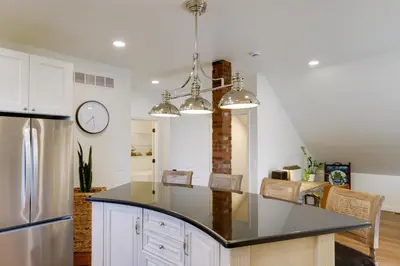 a kitchen with white cabinets and a black counter top at 1 Block to Loveland Bike Trail The Frog Man Inn in Loveland