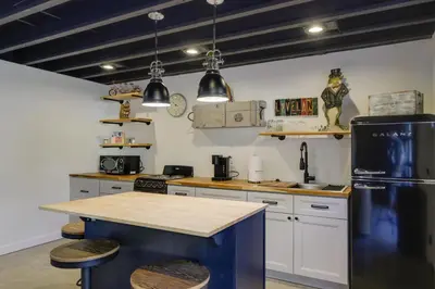 a kitchen with a black refrigerator and white cabinets at Unique Studio on Obanyon Creek in Dtwn Loveland! in Loveland