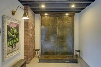 a large metal door in a room with two stools at Unique Studio on Obanyon Creek in Dtwn Loveland! in Loveland