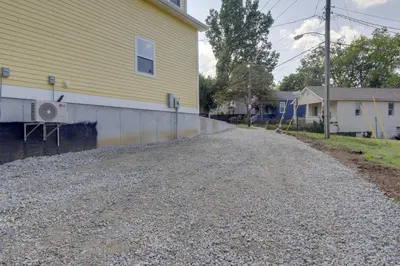 a gravel road next to a yellow house at Unique Studio on Obanyon Creek in Dtwn Loveland! in Loveland