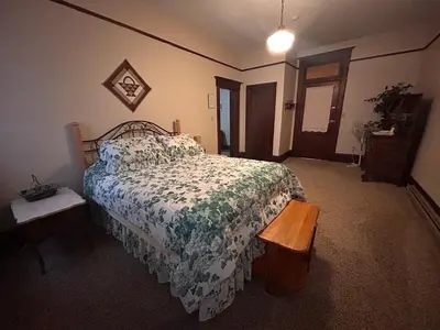 a bedroom with a bed with a floral bedspread at The Historic Hideaway in McConnelsville